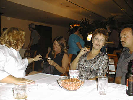 Cheryl Cheek Collier shows Kathy Callaway Birch some pictures, while Joyce Swinney McKinney shows her surprise at being photographed